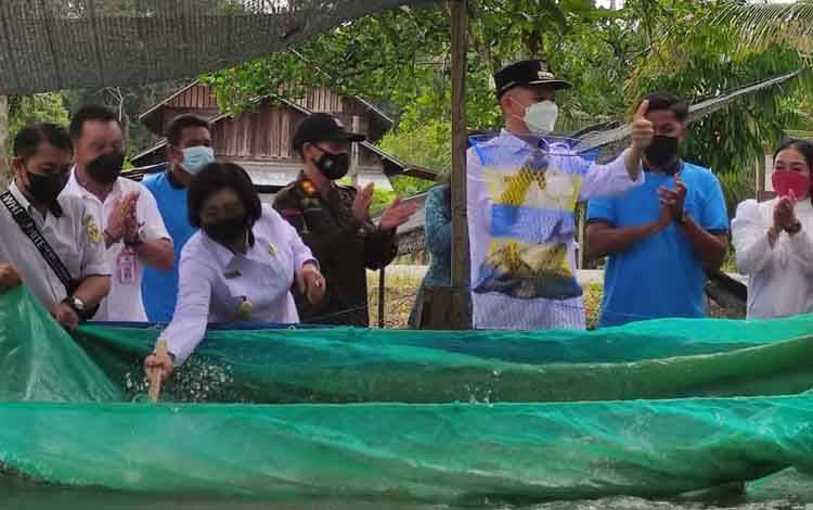 Bupati Gunung Mas Jaya S Monong bersama dengan Wakil Bupati Efrensia L.P Umbing saat menghadiri kegiatan panen ikan patin di Desa Bereng Jun Kecamatan Manuhing pada Rabu, 6 April 2022.