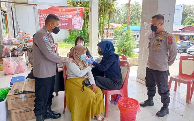 Kapolsek Dusun Timur Iptu Kuslan (kanan) mengawasi kegiatan vaksinasi di Pasar Tamiang Layang, Senin 11 April 2022