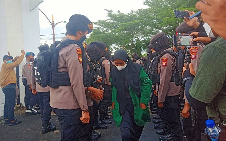 Satu persatu pendemo diperiksa petugas saat memasuki gerbang kantor DPRD Kalteng.