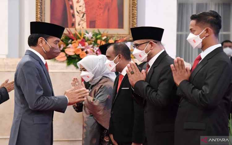 Presiden Jokowi (kiri) memberi ucapan selamat kepada Komisioner KPU dan Bawaslu periode 2022-2027 usai pelantikan di Istana Merdeka, Jakarta, Selasa (12/04/2022)