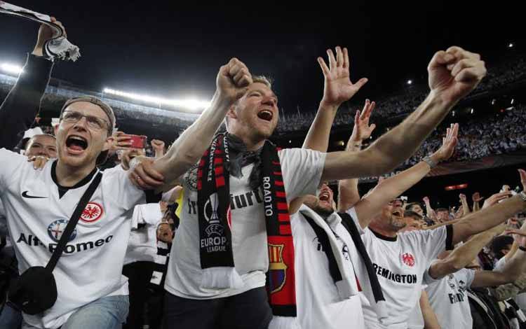 Suporter Eintracht Frankfurt melakukan selebrasi setelah laga leg kedua perempat final Liga Europa antara Eintracht Frankfurt dan Barcelona di Camp Nou, Barcelona, Spanyol. Kamis (14/4/2022)