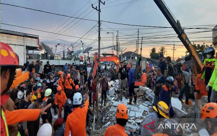 Petugas berupaya melakukan evakuasi korban yang terjebak reruntuhan bangunan Alfamart di Kalsel, Senin (18/4/2022). (ANTARA/Firman)