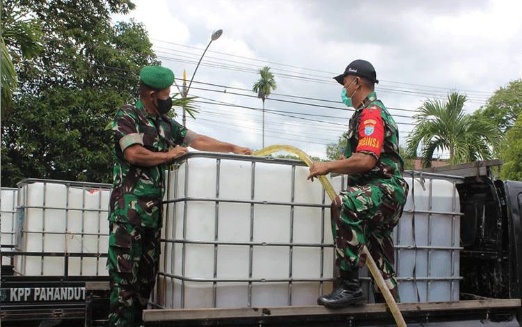 Anggota Kodim Palangka Raya bantu distribusi minyak goreng.