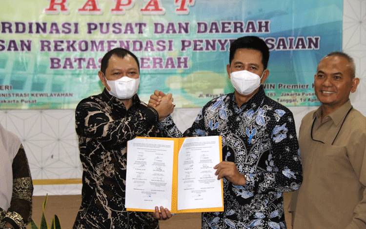 Bupati Barito Utara, H Nadalsyah berjabat tangan dengan Bupati Kabupaten Paser usai penandatanganan kesepakatan tata Batas di Kemendagri.