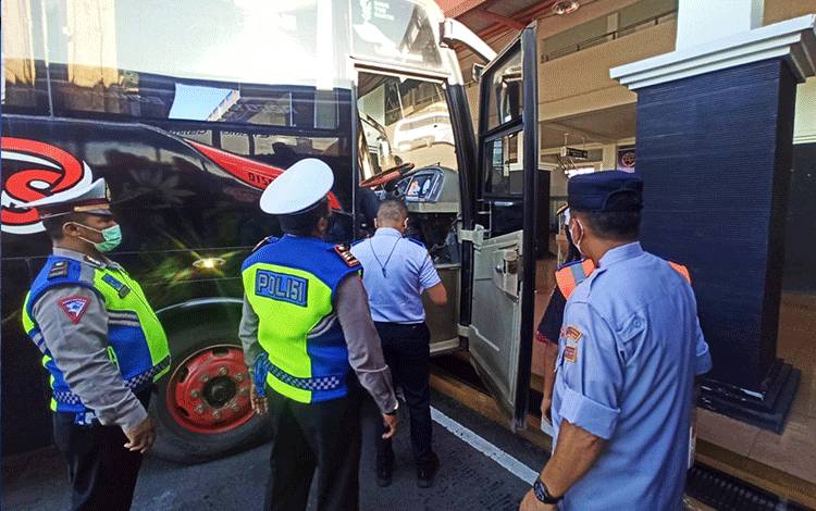 Petugas saat melakukan pengecekan keselamatan angkutan umum.