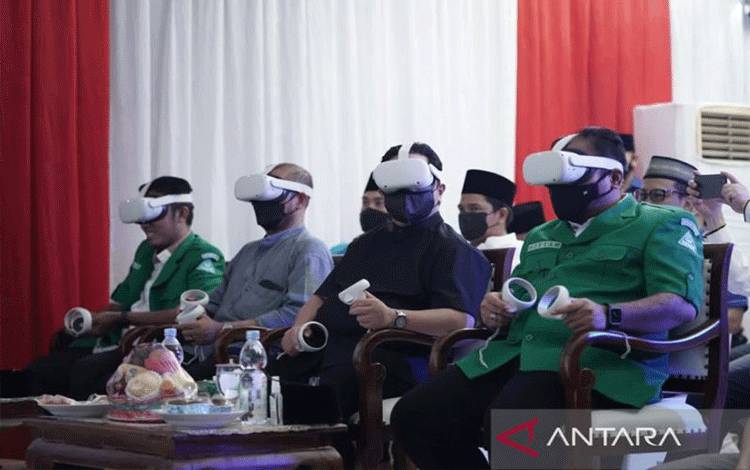 Ketua Umum PP Gerakan Pemuda (GP) Ansor Yaqut Cholil Qoumas atau Gus Yaqut (kanan) dan Menteri BUMN Erick Tohir (dua kanan) mencoa teknologi virtual and augmented reality (VR/AR) di Kantor PP GP Ansor, Jakarta, Minggu (24/2/2022) malam. (ANTARA/HO-Humas Ansor)