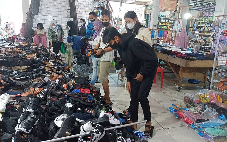 Lapak penjual sendal dan sepatu di Pasar Tamiang Layang ramai dikunjungi pembeli.