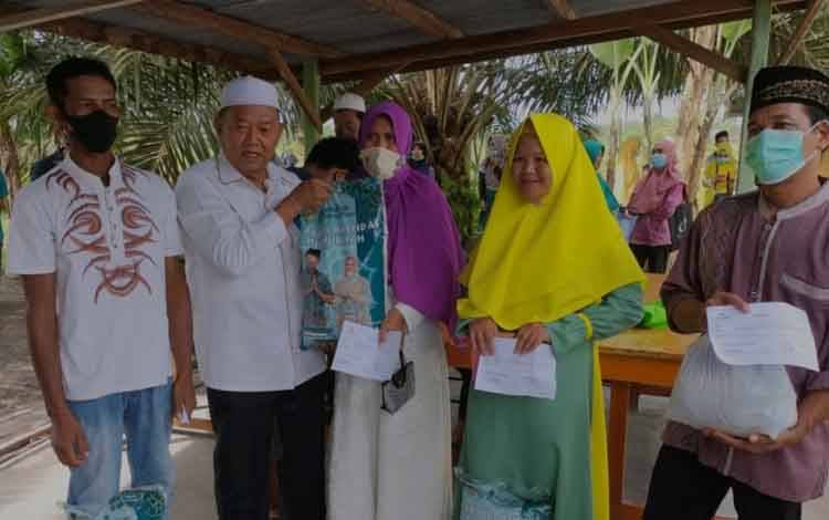 Ketua Baznas Kobar, Suhartono Basran saat menyalurkan zakat harta H. Abdul Rasyid AS dan keluarga kepada warga Kecamatan Kotawaringin Lama