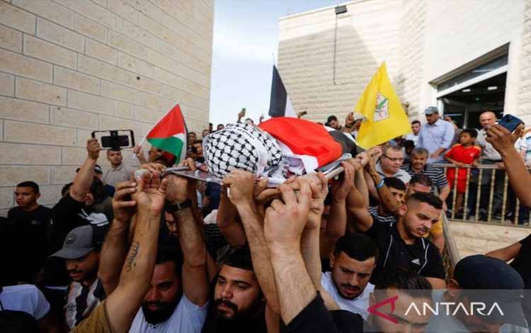 Pelayat membawa jenazah warga Palestina Ahmed Odiyatm yang menurut petugas medis dibunuh oleh pasukan Israel dalam serangan di Jericho, Tepi Barat yang diduduki Israel, 26 April 2022.