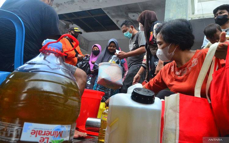 Warga membeli minyak goreng curah saat operasi pasar minyak goreng curah di Balai Desa Tumpangkrasak, Kudus, Jawa Tengah, Selasa (26/4/2022). . ANTARA FOTO/Yusuf Nugroho/aww.