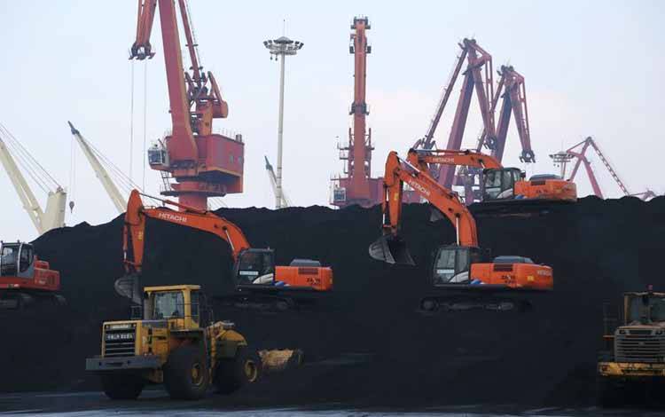 Pekerja mengoperasikan alat berat untuk membongkar batu bara impor di pelabuhan Lianyungang, Provinsi Jiangsu, China, 5 Desember 2019
