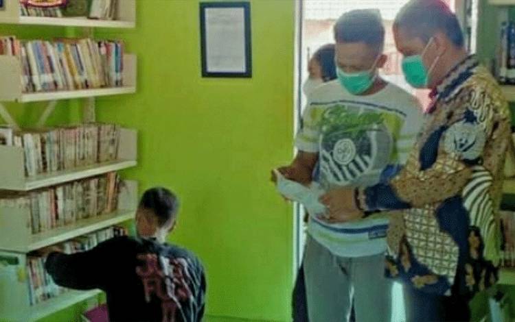 Kasubsi Pelayanan Tahanan Rutan Kuala Kapuas, Wahyu Cahyadi saat merapikan perpustakaan Rutan setempat.