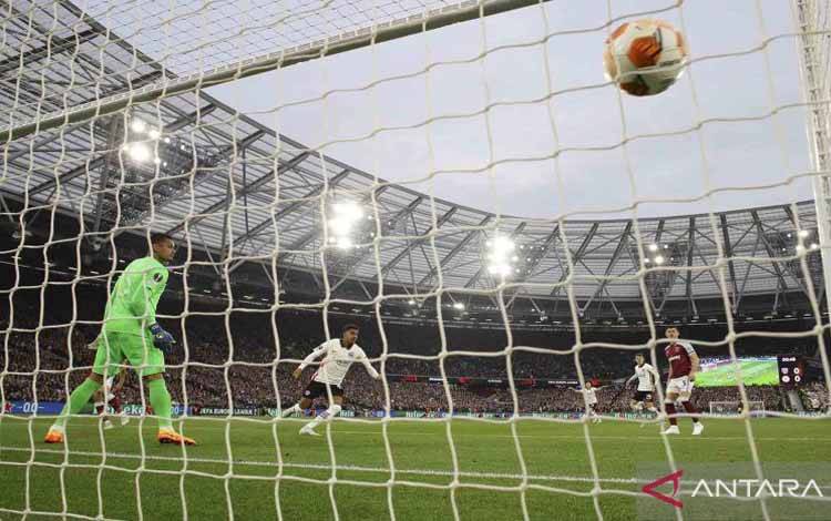 main Eintracht Frankfurt Ansgar Knauff mencetak gol ke gawang West Ham United yang dijaga Alphonse Areola (kiri) pada pertandingan babak Semi Final leg pertama Liga Eropa di Stadion London, London, Inggris, Kamis (28/4/2022). West Ham United tumbang 1-2 saat menjamu Eintracht Frankfurt di laga tersebut.