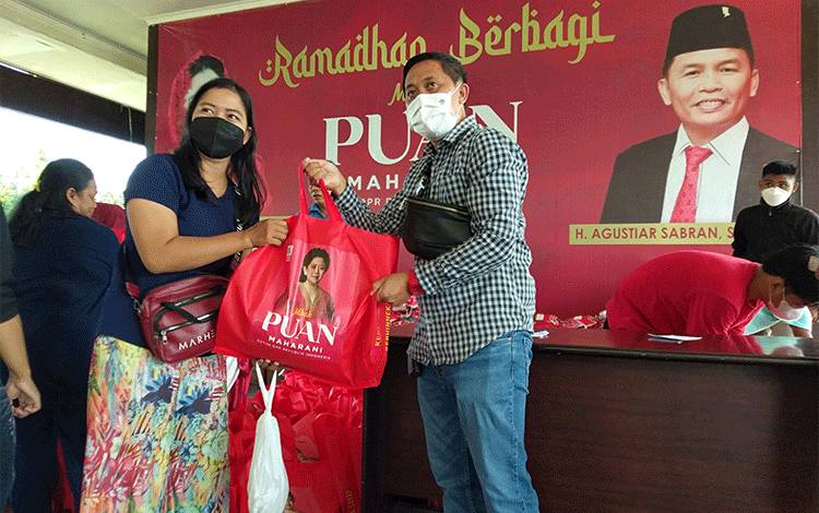 Sigit Wido (kanan) mewakili Agustiar Sabran menyerahkan secara simbolis paket sembako kepada warga di Palangka Raya, Sabtu, 30 April 2022. 