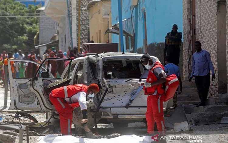 Paramedis bersiap memindahkan mayat seorang pria ke kantung jenazah, di lokasi ledakan di Mogadishu, Somalia, 16 Januari 2022
