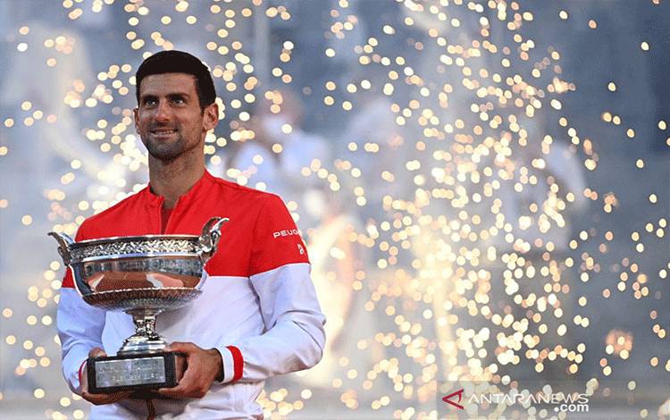Petenis Serbia Novak Djokovic berpose dengan Piala The Mousquetaires Cup setelah menaklukkan petenis Yunani Stefanos Tsitsipas dalam final French Open di Roland Garros, Paris, 134 Juni 2021. ANTARA/AFP/ANNE-CHRISTINE POUJOULAT/pri.