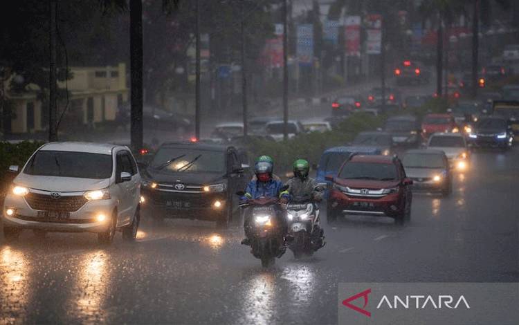 Pengendara menerobos hujan lebat saat melintasi jalan protokol Palembang. (ANTARAFOTO/Nova Wahyudi)