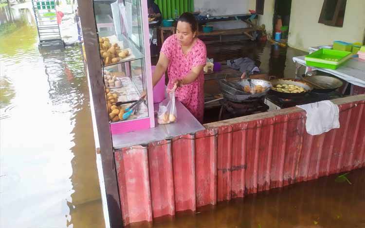 Sejumlah pedagang di Sampit tetap beraktivitas di tengah genangan air setelah diguyur hujan