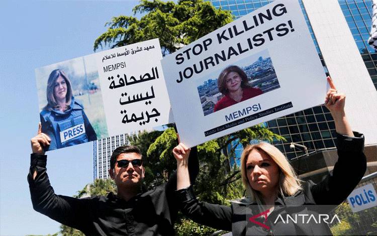Pengunjuk rasa pro-Palestina membawa spanduk dengan gambar jurnalis Al Jazeera Shireen Abu Akleh, yang tewas dalam serbuan Israel di Jenin, selama aksi protes di depan konsulate Israel, di Istambul, Turki, Kamis (12/5/2022). ANTARA FOTO/REUTERS/Dilara Senkaya/FOC/djo