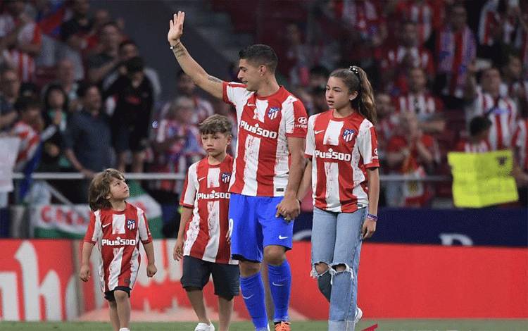 Luis Suarez dan tiga anaknya melambaikan tangan kepada suporter Atletico Madrid usai pertandingan lawan Sevilla pada 16 Mei 2022. ANTARA/AFP/JOSE JORDAN