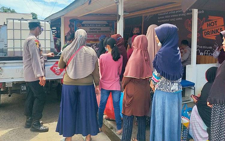 Kapolsek Dusun Tengah Ipda Supriyadi mengawasi langsung masyarakat yang mengantre minyak goreng curah murah.