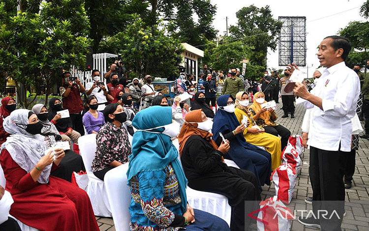 Presiden Joko Widodo (Jokowi) berbincang dengan sejumlah warga sembari membagikan bantuan langsung tunai dan paket sembako di Pasar Muntilan, Kabupaten Magelang, Jawa Tengah, Sabtu (21/5/2022). ANTARA/HO-Biro Pers Setpres/Rusman/aa. (Handout Biro Pers Sekretariat Kepresidenan/Rusman)