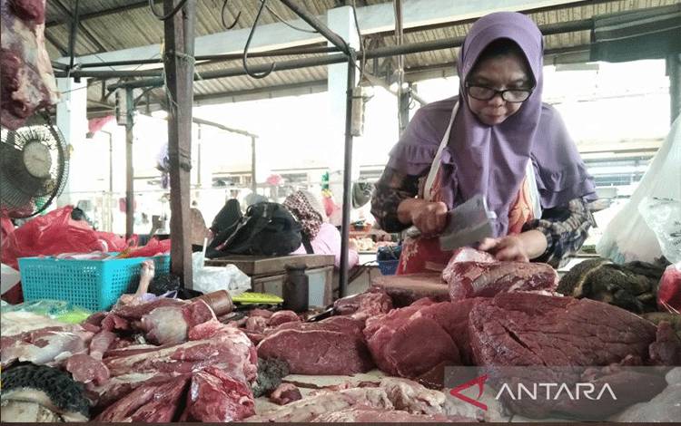 Pedagang tengah memotong daging sapi untuk melayani pembeli. (ANTARA/Akhmad Nazaruddin Lathif)