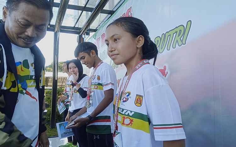 Atlet asal Barito Timur Viyana Lestari saat menerima piagam dan pengalungan medali usai meraih juara 1 lomba lari 5.000 meter di Banjarbaru