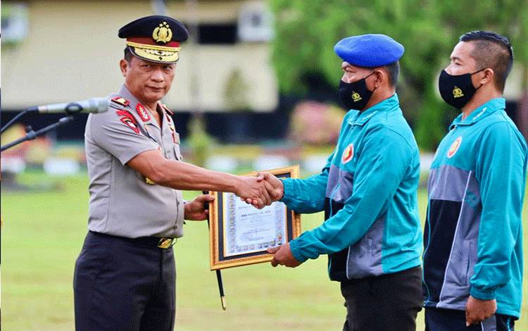  Kapolda Kalteng Irjen Pol Nanang Avianto saat memberikan piagam penghargaan kepada salah satu anggota berprestasi.