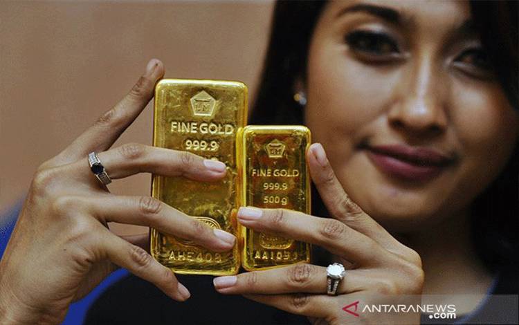 Seorang petugas memperlihatkan emas batangan produksi PT Antam di Jakarta, Senin (19/1).(ANTARA FOTO/Wahyu Putro A/ss/ama/15)