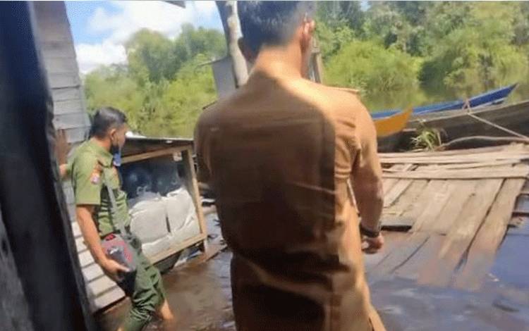 Kepala Desa Bagendang Tengah Ramban, Untung Sukardi menunjukkan lokasi penyerangan buaya terhadap warga kepada Komandan BKSDA Pos Jaga Sampit, Muriansyah.