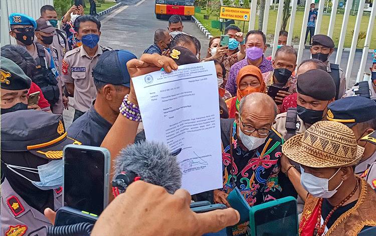 Humas Pengadilan Tinggi Palangka Raya saat menemui massa untuk memberitahukan surat keputusan penonaktifan sementara 3 Majelis Hakim.