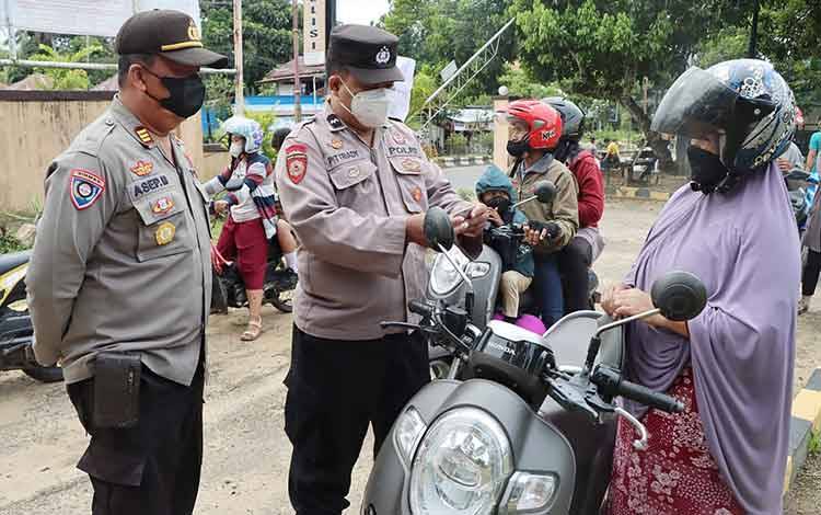 Petugas memeriksa kartu vaksin pengguna jalan yang melintas di depan Mapolsek Dusun Timur.