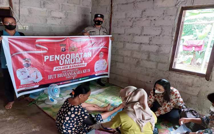 Personel Polsek Basarang dan tim medis UPT Puskesmas Basarang saat memberikan pengobatan kepada warga di Desa Batu Nindan