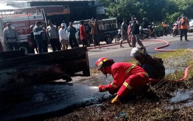 Petugas Damkar Kobar saat memadamkan api yang membakar mobil Pikap di Kumai.