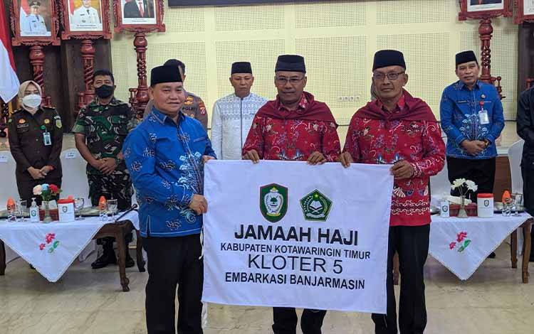 Bupati Kotim Halikinnor saat menyerahkan bendera jemaah calon haji kloter 5 embarkasi Banjarmasin, kepada ketua rombongan pada kegiatan pelepasan 91 JCH Kotim.
