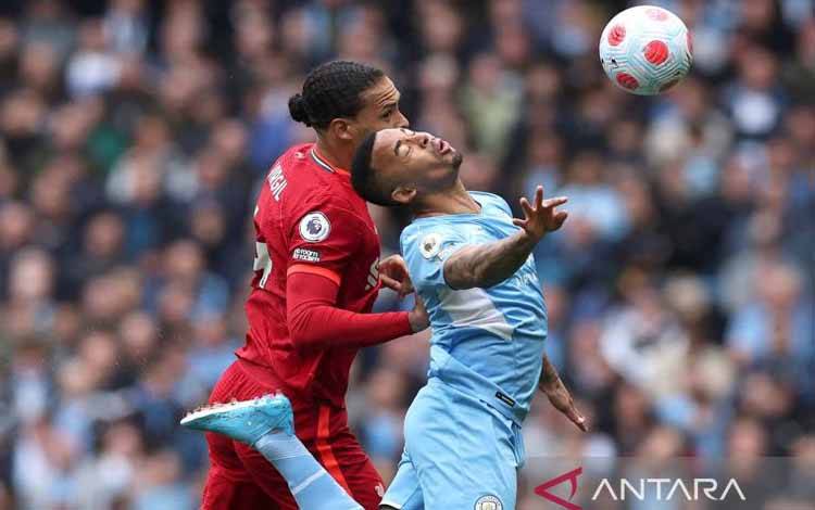 Penyerang Manchester City Gabriel Jesus berebut bola dengan bek Liverpool Virgil van Dijk pada laga Liga Inggris di Etihad Stadium, Manchester, Inggris (10/4/2022)