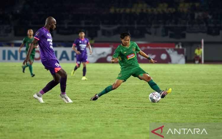 Pemain depan PSS Sleman Riki Dwi Saputro (kostum hijau hijau) saat mengontrol bola dan dijaga ketat pemain Persita tangerang Yohanes Kandimu (kostum Ungu-ungu) dalam laga Grup A Turnamen Piala Presiden 2022, di Stadion Manahan Solo, Kamis 916/6/2022)