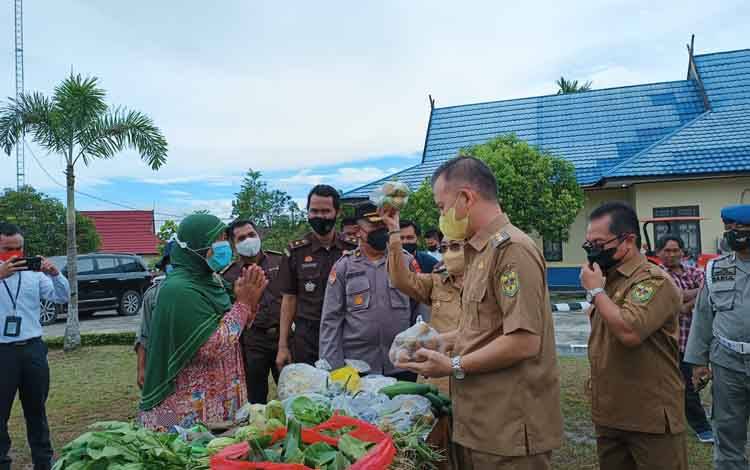 Bupati Gunung Mas, Jaya S Monong dan Wakil Bupati Efrensia L.P Umbing sedang meninjau pasar tani di halaman Kantor Dinas Pertanian, Senin 20 Juni 2022