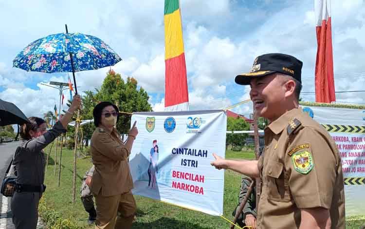 Bupati Gunung Mas Jaya S Monong bersama Wakil Bupati Efrensia L.P Umbing saat memasang spanduk anti narkoba untuk memecahkan rekor MURI pesangan spanduk terbanyak