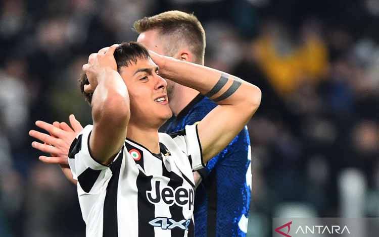 Pemain Juventus Paulo Dybala memegang kepala saat melawan Inter Milan dalam laga sepak bola Liga Italia di Allianz Stadium, Turin, Italia, Minggu (3/4/2022). Inter berhasil mencuri tiga poin di kandang Juve dengan kemenangan 1-0. ANTARA FOTO/REUTERS/Massimo Pinca/foc.