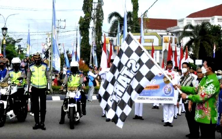Bupati Barito Utara H Nadalsyah didampingi wakil bupati dan pejabat lainnya saat mengibarkan bendera star melepas pawai karnaval dalam rangka Hari Jadi ke 72 Kabupaten Barito Utara, Kamis 23 Juni 2022.