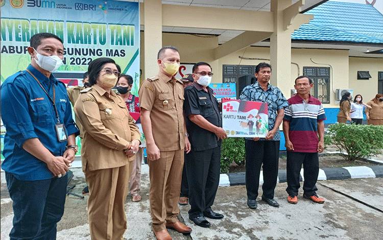 Ketua DPRD Kabupaten Gunung Mas Akerman Sahidar saat menyerahkan secara simbolis kartu tani pada petani setempat.