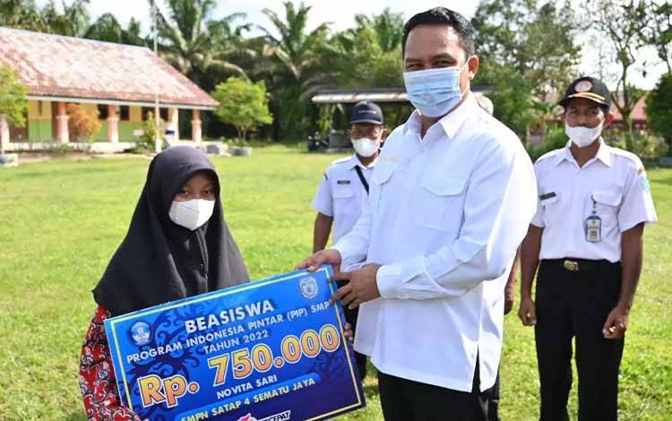 Bupati Lamandau Hendra Lesmana menyalurkan beasiswa Program Indonesia Pintar kepada salah satu murid SDN 1 Mekar Mulya. Kecamatan Sematu Jaya