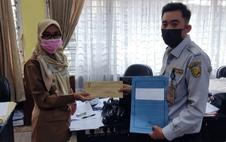 Pegawai Dishub Palangka Raya menyerahkan surat pemberitahuan wajib KIR kendaraan dinas.