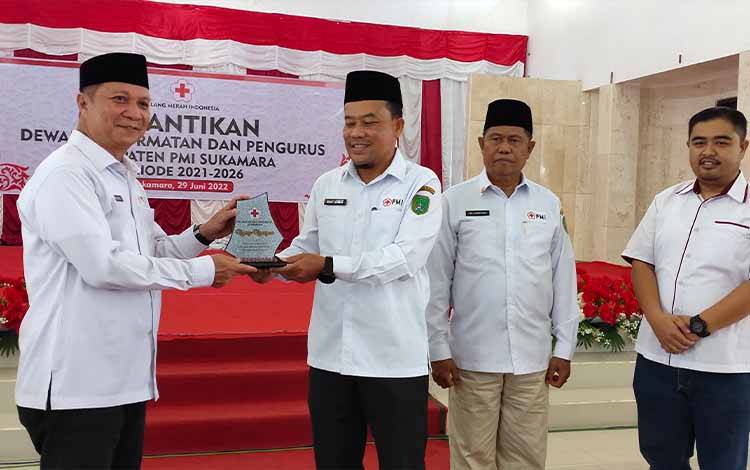 Ketua PMI Kabupaten Sukamara saat menyerahkan cendra mata kepada Ketua Pengurus PMI Provinsi Kalteng, H Suhaemi.