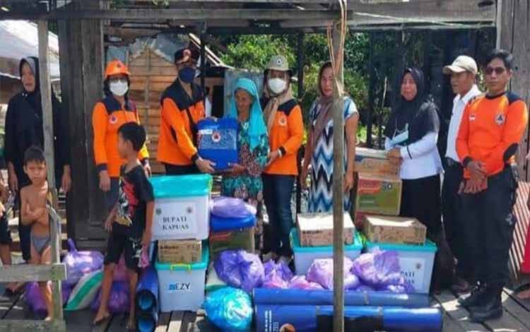 Petugas BPBD Kapuas saat menyalurkan bantuan kepada warga terdampak kebakaran rumah di Desa Mantangai Tengah, Rabu 29 Juni 2022