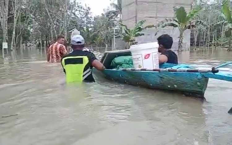(Tangkapan layar) Tampak sejumlah warga Desa Sungai Hijau mengevakuasi barang-barang dari banjir.