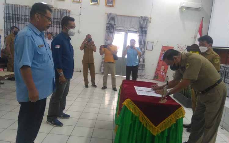 Sekda Kabupaten Gunung Mas Yansiterson menandatangani berita acara Sertijab Direktur PDAM Tirta Bahalap Gumas di Aula Bappedalitbang pada Senin, 27 Juni 2022.