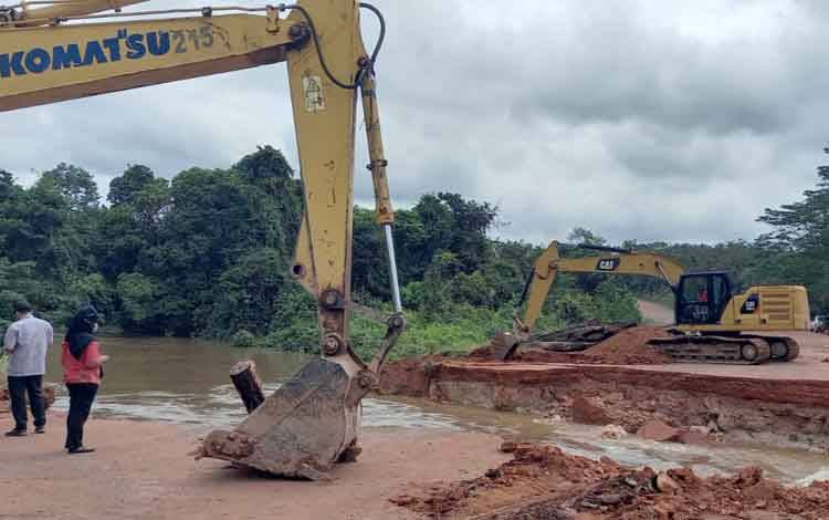 Tampak alat berat sedang melakukan perbaikan Jembatan jalan Aspec, di Desa Sungai Kuning, Kecamatan Pangkalan Banteng